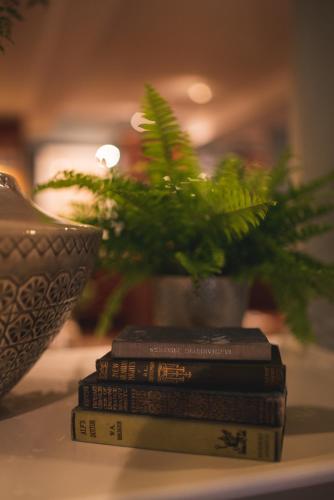 a stack of books sitting on a table with a plant at Arrow Mill- Brunning and Price in Alcester