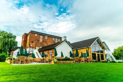 a building with tables and chairs in the grass at Arrow Mill- Brunning and Price in Alcester