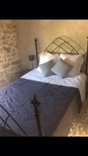 a bedroom with a bed with two pillows at Fort de la Bastide in Uzer