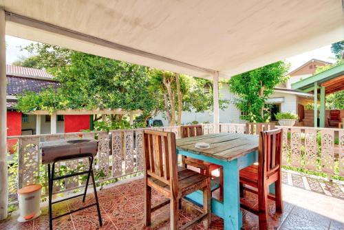 une table bleue et des chaises sur une terrasse dans l'établissement Rosemary House, à Pak Chong