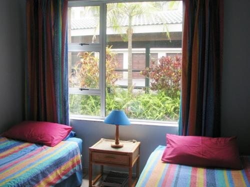 1 Schlafzimmer mit 2 Betten und einem großen Fenster in der Unterkunft Ramsgate Palms B in Ramsgate