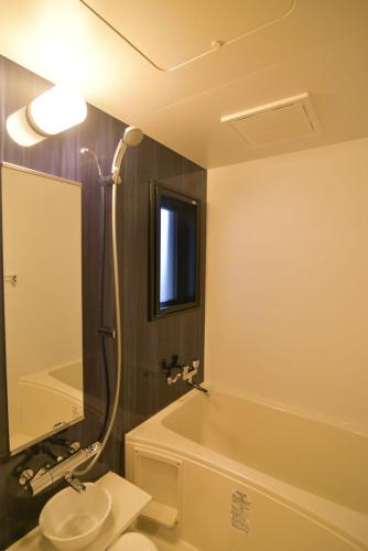 a bathroom with a shower and a sink and a tub at European House Reisen in Fukuoka