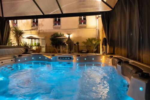 a jacuzzi tub in the middle of a building at Hôtel De Brunville & Spa in Bayeux