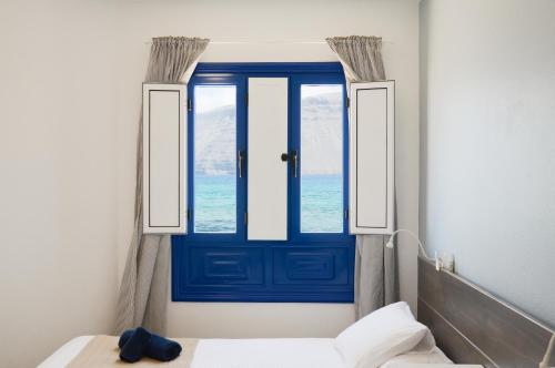 eine blaue Tür in einem Zimmer mit Fenster in der Unterkunft Apartamentos El Marinero - Caletilla in Caleta de Sebo