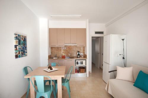 um pequeno apartamento com uma mesa e cadeiras e uma cozinha em Apartamento a pie de playa, climatizado y parking em Roses