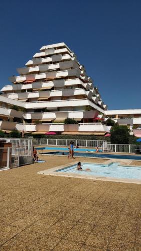 un bâtiment sur la plage avec une piscine et un bâtiment dans l'établissement Studio vue panoramique-centre ville, à La Grande Motte