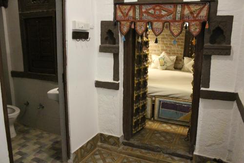 a bathroom with a mirror in a room with a bed at Castle View Heritage Haveli in Jodhpur