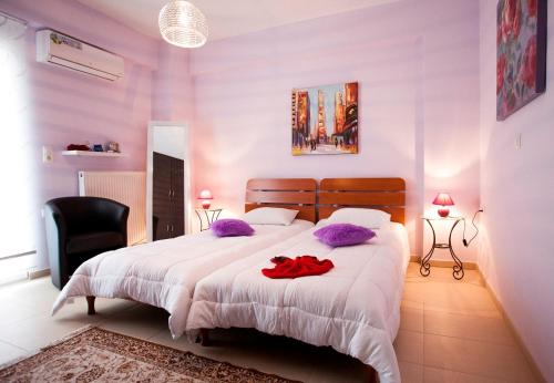 レティムノ・タウンにあるElena & Pelagia Luxury Apartmentのベッドルーム1室(大型ベッド1台、紫色の枕付)