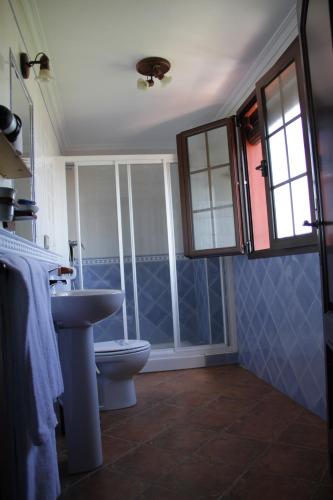 a bathroom with a sink and a toilet at Hostal Pechi in Huévar