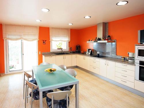 リョレート・デ・マルにあるVilla Adelaida by Interhomeのオレンジ色の壁のキッチン(テーブル、椅子付)