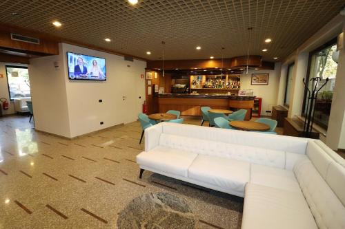 a living room with a white couch and a bar at Hotel Domenichino in Milan