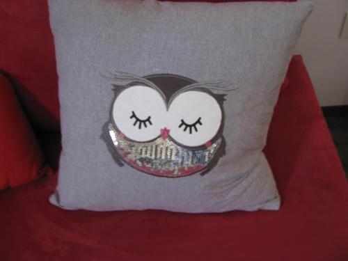 a pillow with a face on it sitting on a red couch at Gästequartier Schlummerkasten in Sievern