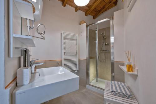a white bathroom with a sink and a shower at Drom Florence Rooms & Apartments in Florence