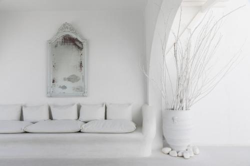 a white living room with a white couch and a vase at Mykonos Bay Resort & Villas in Mýkonos City