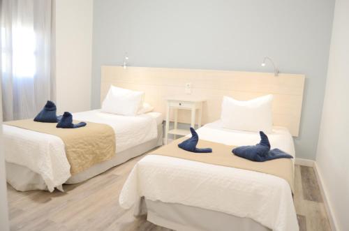 1 dormitorio con 2 camas y toallas azules. en Apartamentos El Marinero - Iglesia, en Caleta de Sebo
