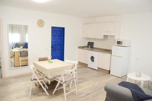 a kitchen and a living room with a table and chairs at Apartamentos El Marinero - Iglesia in Caleta de Sebo