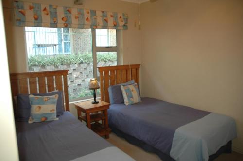 a bedroom with two beds and a window at Ramsgate Palms D in Ramsgate