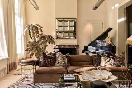 a living room with a brown couch and a fireplace at Hotel Van Cleef in Bruges