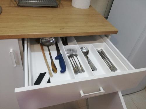 a drawer with utensils in it under a table at Apartment Teodora in Belgrade