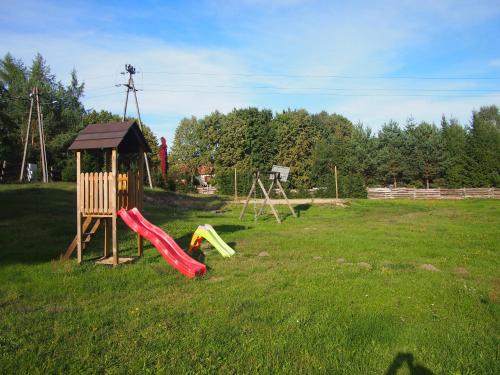 a playground with a slide in a field at Dar Lasu in Szczytno
