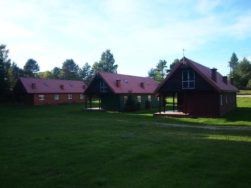 two barns with red roofs on a green field at Dar Lasu in Szczytno