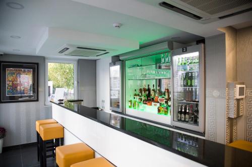 a bar in a restaurant with a drink cooler at Hotel Tommasi in Mörfelden-Walldorf