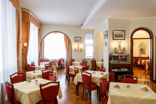 um restaurante com mesas e cadeiras num quarto em Hotel Continental em Treviso