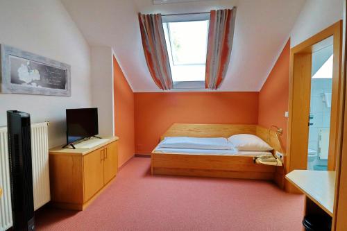 Habitación pequeña con cama y ventana en Gasthof Huber, en Wels
