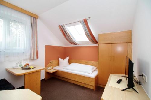 a small bedroom with a bed and a window at Gasthof Huber in Wels