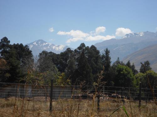 a fence in a field with mountains in the background at "Dulces Sueños" in Cochabamba