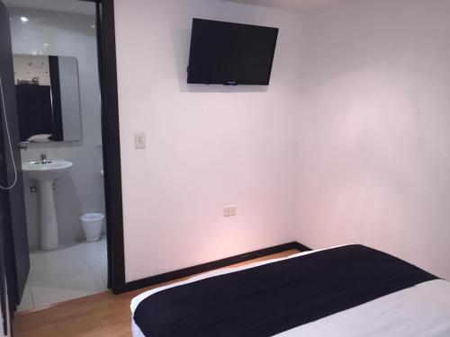 sypialnia z łóżkiem i telewizorem na ścianie w obiekcie Hotel Montecarlo Boutique w mieście Bogota