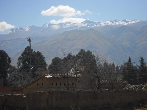 a view of a mountain range with a house and a fence at "Dulces Sueños" in Cochabamba