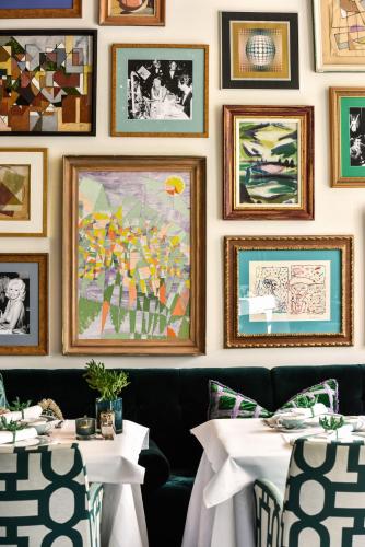 a dining room with two tables and pictures on the wall at Hotel Van Cleef in Bruges