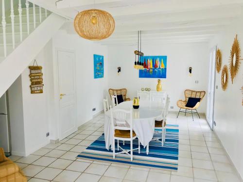 une salle à manger blanche avec une table et des chaises blanches dans l'établissement Villa LE TROIS MÂTS, à Arcachon