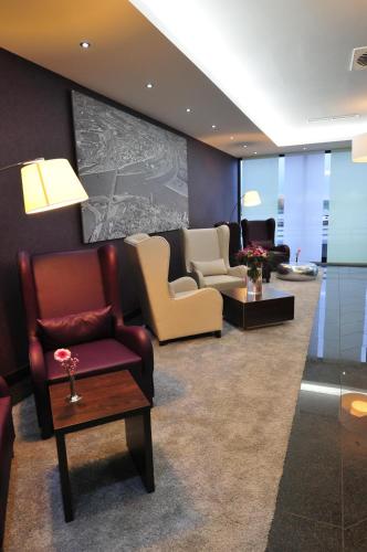 a waiting room with chairs and tables in a building at Hotel Rheingarten in Duisburg