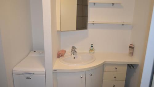 a white bathroom with a sink and a counter at Soniat House in Kestrup