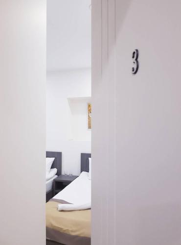 a bedroom with white walls and a bed at Hotel Classic in Tbilisi City