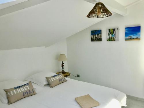 アルカションにあるVilla LE TROIS MÂTSの白いベッドルーム(白いベッド1台、枕2つ付)