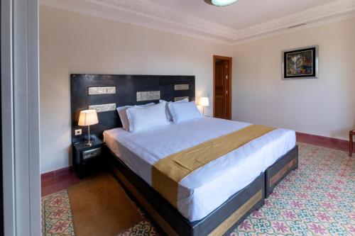 a bedroom with a large bed in a room at Hôtel Riad Airport Marrakech in Marrakech