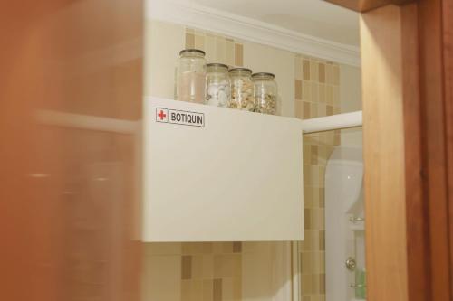 a cabinet filled with bottles of seasoning in a bathroom at Estancia de Invitados de Casa Tais in Málaga