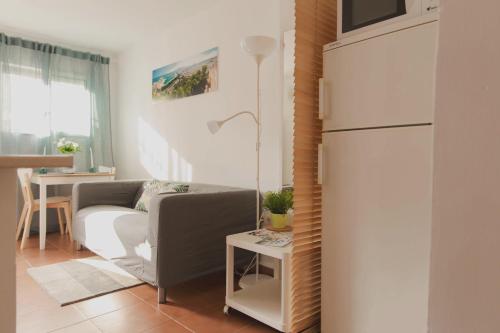 a living room with a couch and a refrigerator at Estancia de Invitados de Casa Tais in Málaga