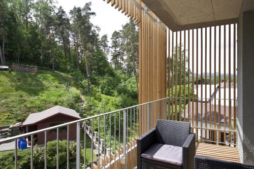 un porche con una silla en el balcón en Lakepark Residence en Staré Splavy