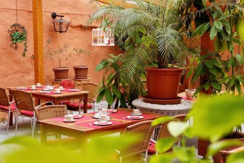 a patio with two tables and chairs and plants at Hotel Zum Römer in Überlingen