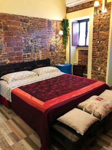 a bed in a room with a brick wall at IL Vicoletto in Serra San Bruno