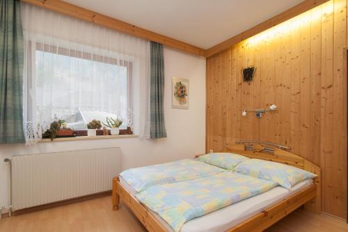 Posto letto in camera con parete in legno. di Lug ins Land a Spittal an der Drau