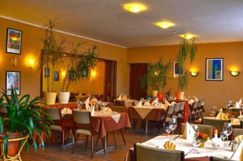 a dining room with tables and chairs in a restaurant at Hotel Restaurant Zur Hexe in Überherrn