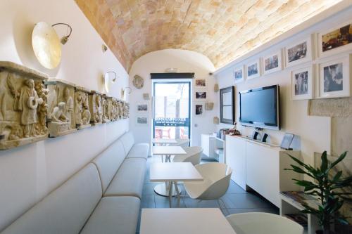 a living room with white furniture and a ceiling at Hotel Museu Llegendes de Girona in Girona
