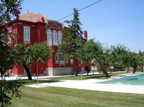 a red house with a pool in front of it at Casa Vermelha in Vila Nova de Foz Coa