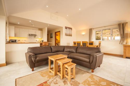 a living room with a brown couch and a table at Panorama Cottages in Llangollen