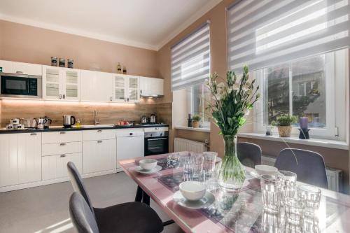 a kitchen with a table with a vase of flowers on it at APT with sunny garden Prague by Michal&Friends in Prague